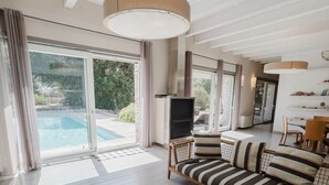 A spacious living room with a large sofa, a flat-screen TV, and a dining area. - Villa Bohème-chic-Villa-Private Bathroom-Deluxe (Bonifacio)