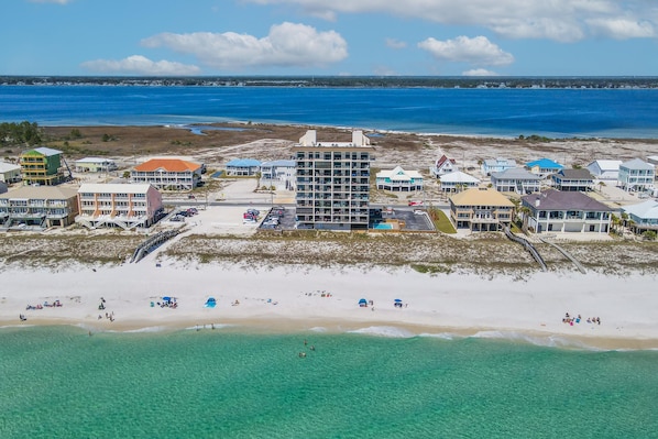 A coastal hotel with multiple buildings, a beach, and a view of the ocean.