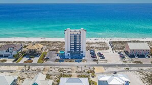 Ein Hochhaus-Hotel mit Innenhof, Parkplatz und Zugang zum Strand.