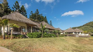 A resort with thatched-roof villas, a pool, and lush greenery. - Ferney Nature Lodge (Vieux Grand Port)