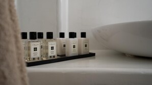 En badeværelseshylde med flere produkter fra Jo Malone London.