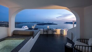 A modern room with a view of the sea, a small pool, and a dining area with a table and chairs. - WeSense by Caldera Houses (Santorini)