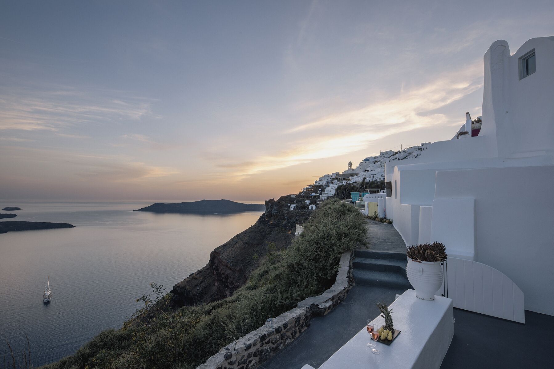 A coastal view with white buildings, a clear sky, and a calm sea.