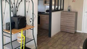 A compact living space with a kitchenette, a dining area, and a small seating area. - T2 in the countryside near greenway. (Banvou)