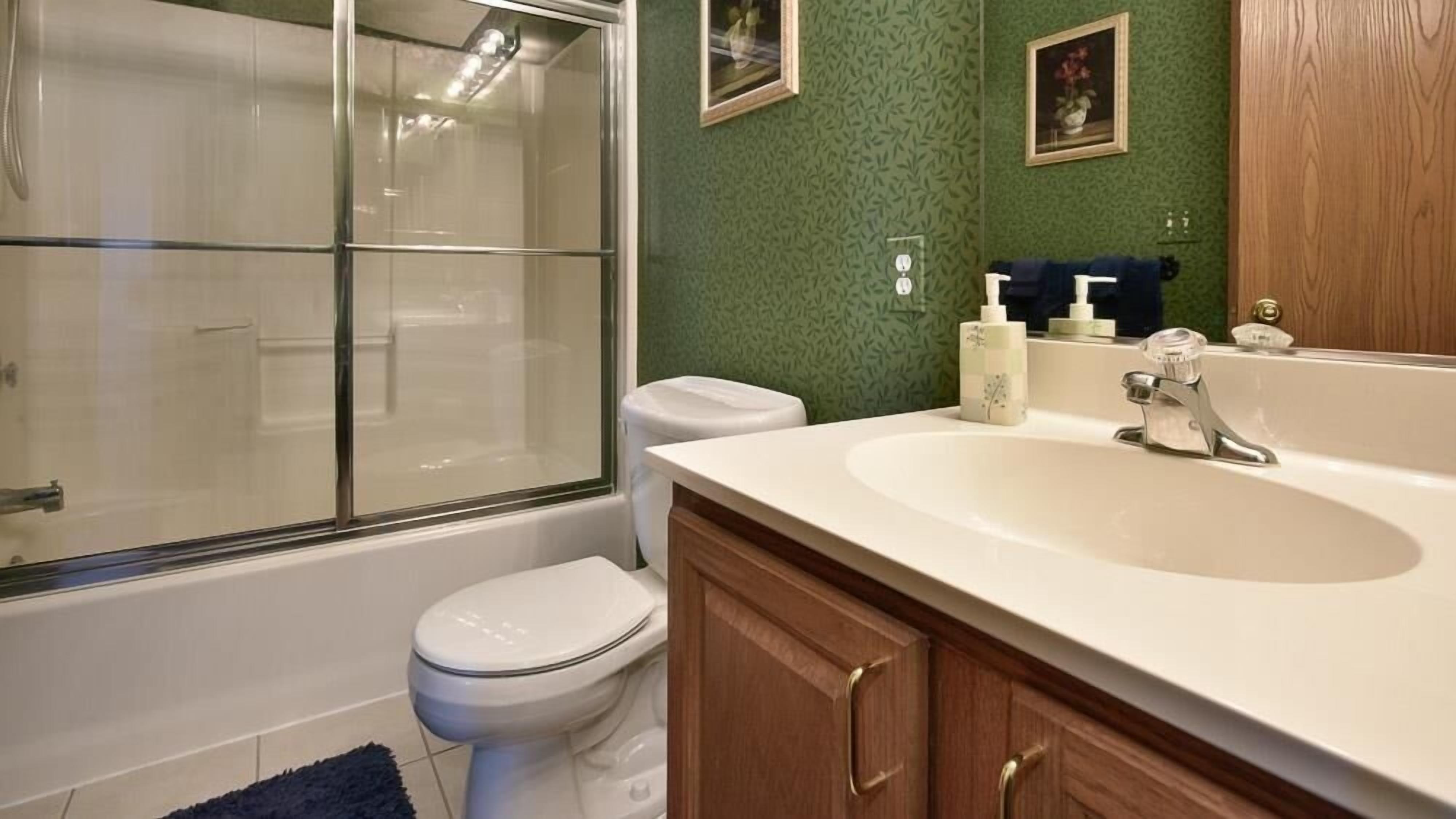 A bathroom with a bathtub, toilet, and sink.