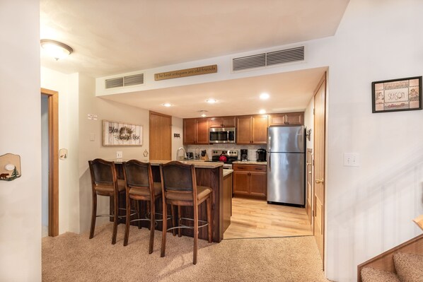 Enjoy cooking in this well-equipped kitchen with a central island, microwave, stove, and refrigerator.