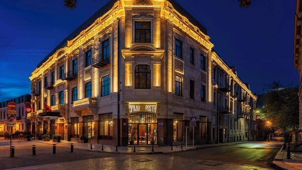 Un edificio histórico con arquitectura ornamentada y una entrada bien iluminada.
