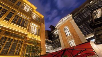 A multi-story building with illuminated windows and a red awning.