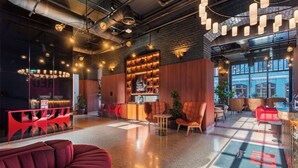 Un interior moderno con una zona de bar, asientos y un amplio ventanal que proporciona luz natural.