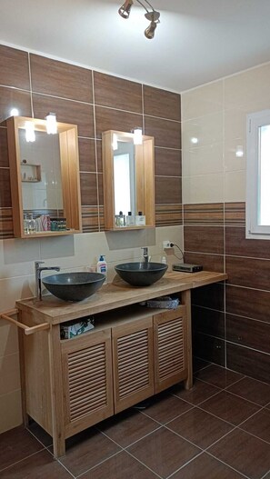 Chuveiro, secador de cabelo, toalhas de banho, papel higiênico