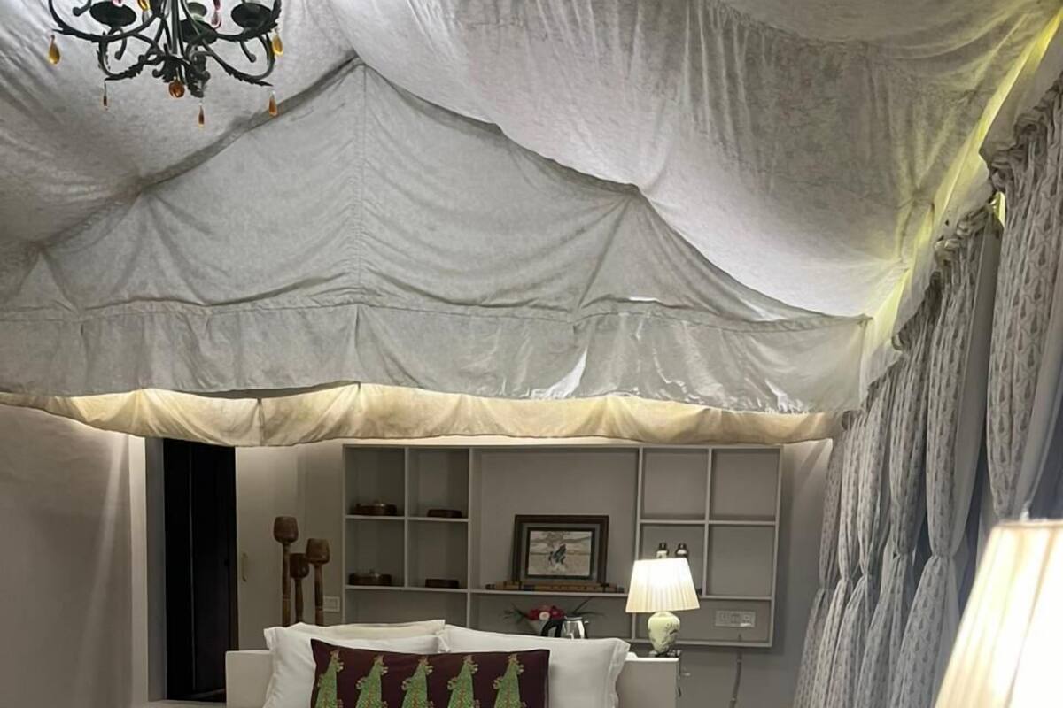 Un dormitorio amplio con una cama grande, mesitas de noche y una lámpara.