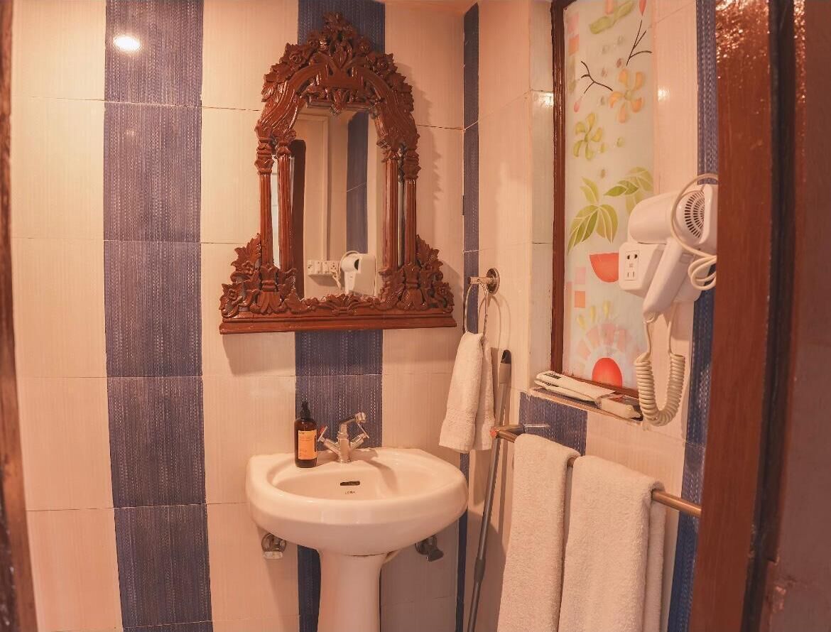 Un baño con lavamanos, espejo y secador de pelo.