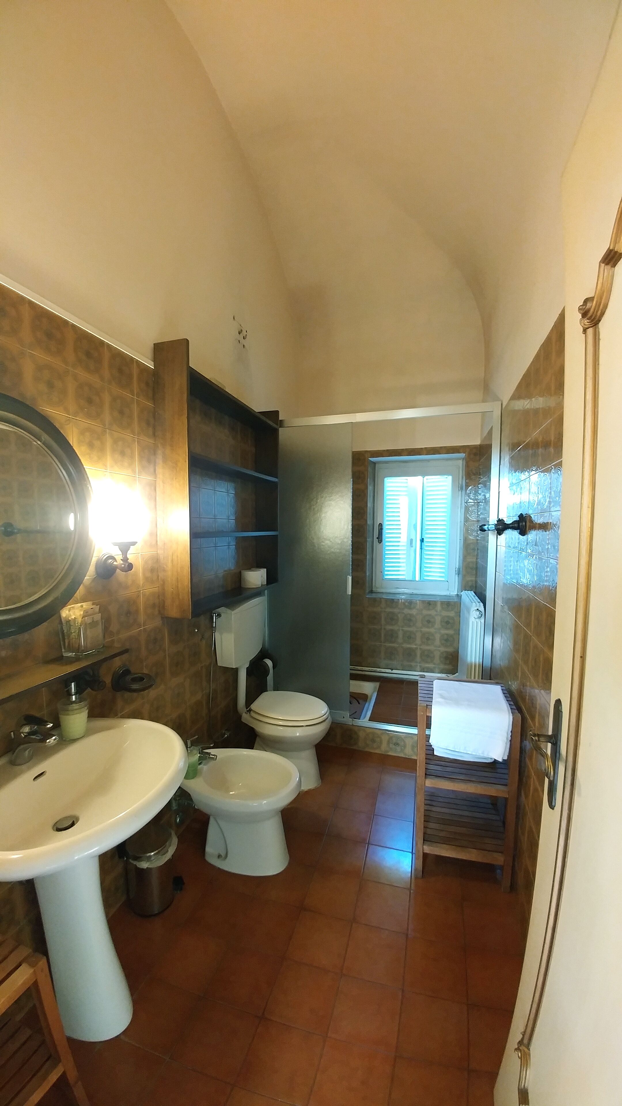 Une petite salle de bain comprenant un lavabo, deux toilettes et une fenêtre.