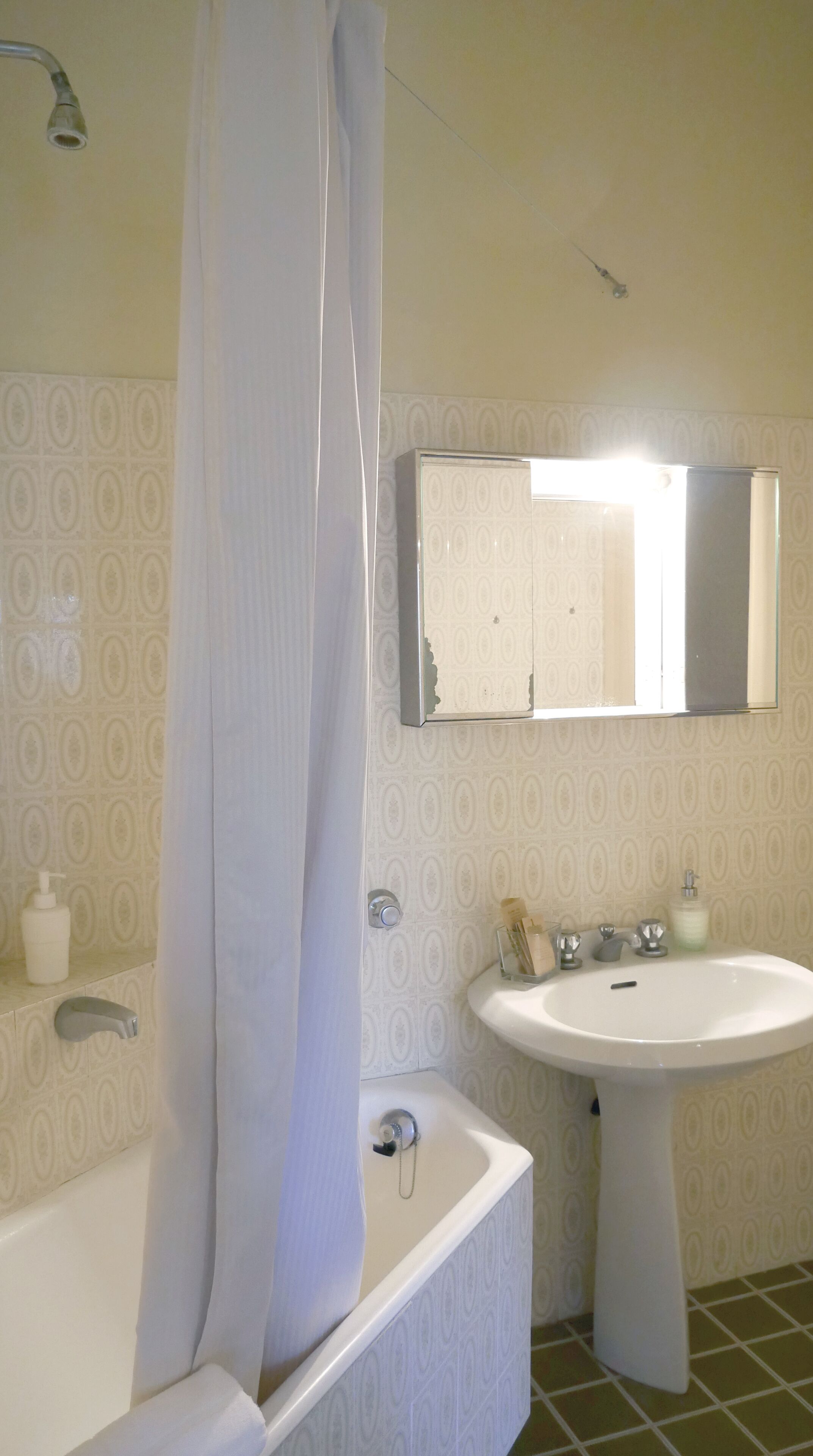 A bathroom with a bathtub, a sink, and a mirror.