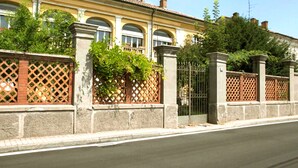 A yellow building with arched windows and a brick fence. - Bresbot (Bressana Bottarone)