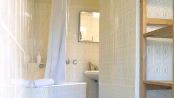 Une salle de bain avec une baignoire, un lavabo et un miroir.