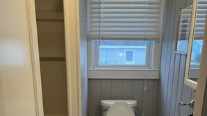 Un baño con inodoro, lavabo y ventana.