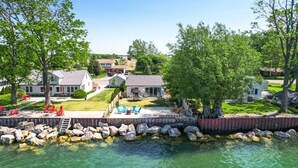 A lakeside property with a patio, outdoor seating, and a view of the water.