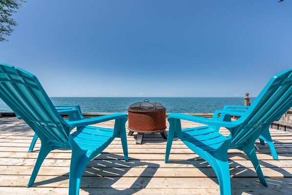 Relax in a serene outdoor space with a deck, two chairs, and a cooking stove.
