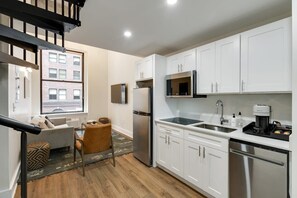 Kitchen features a microwave, double sink, and dishwasher, with a dining area nearby.