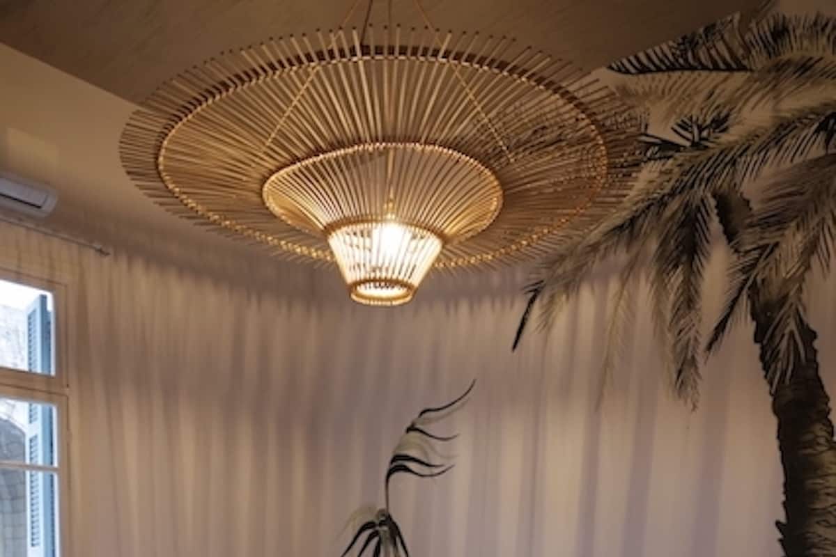 A bed with a wooden headboard, a patterned floor, and a ceiling light fixture.