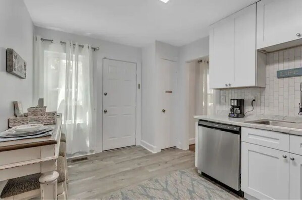 A kitchen with white cabinets, a dishwasher, and a coffee maker. - Tigers! Near Clemson. (Easley)