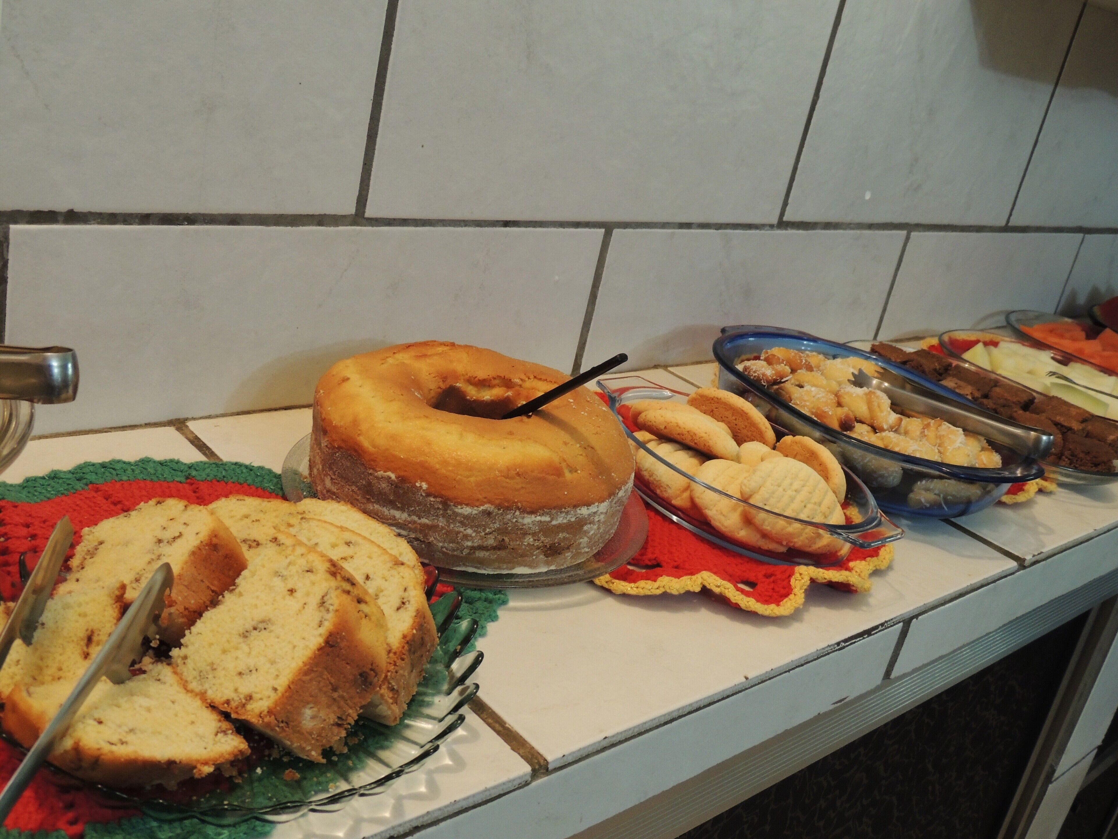 A buffet table with various food items including a cake, cookies, and a variety of other dishes.