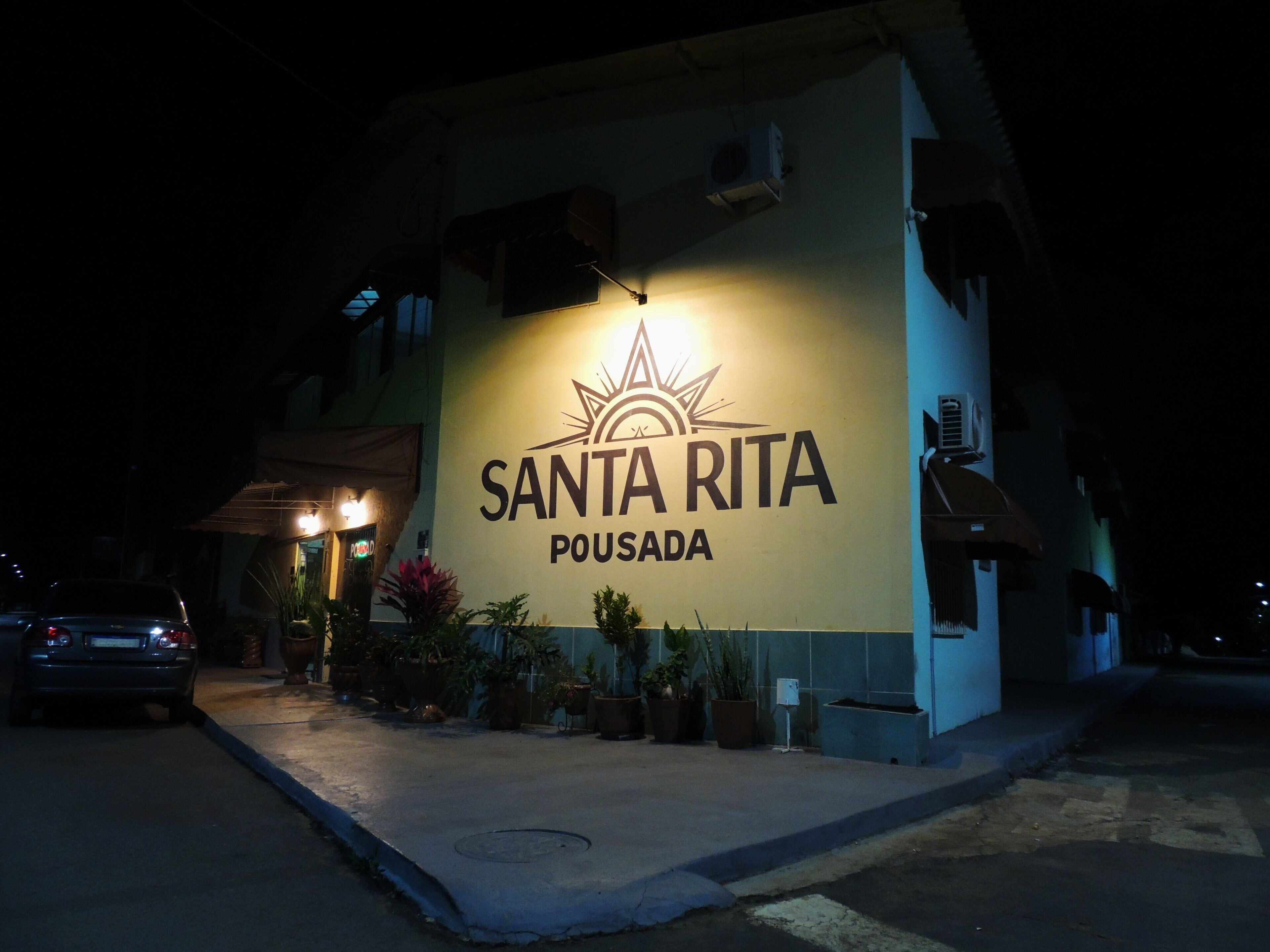 A building with a sign reading 'SANTA RITA POUSA DA' at night.
