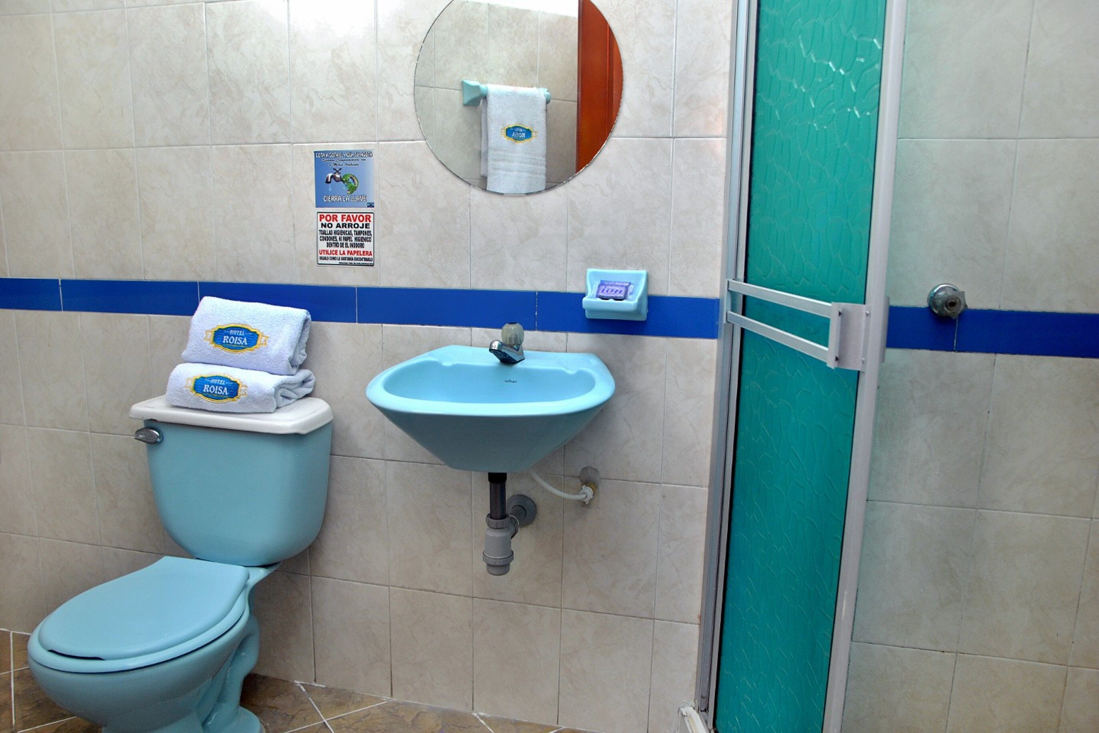 Ein Badezimmer mit Toilette, Waschbecken und Duschabtrennung.