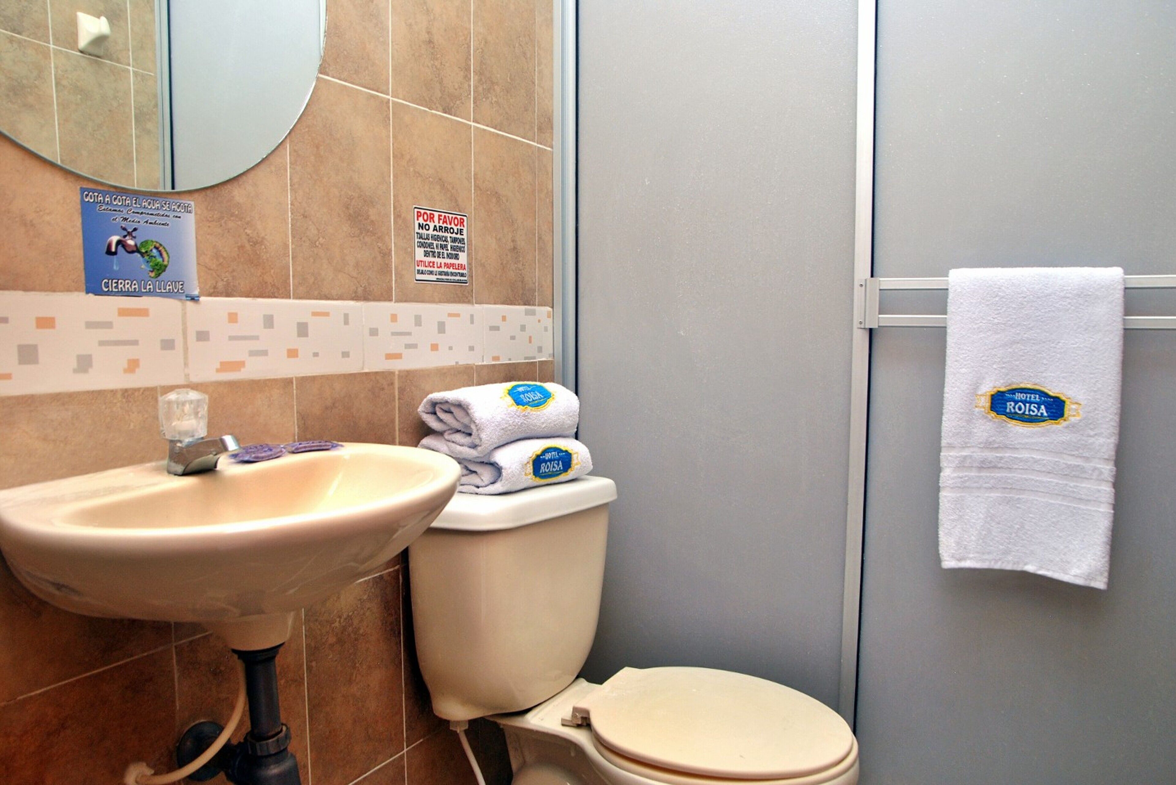 Un baño con lavamanos, inodoro y toallero.