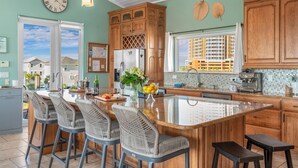 Una cocina moderna con una isla grande, armarios de madera y vistas al exterior.