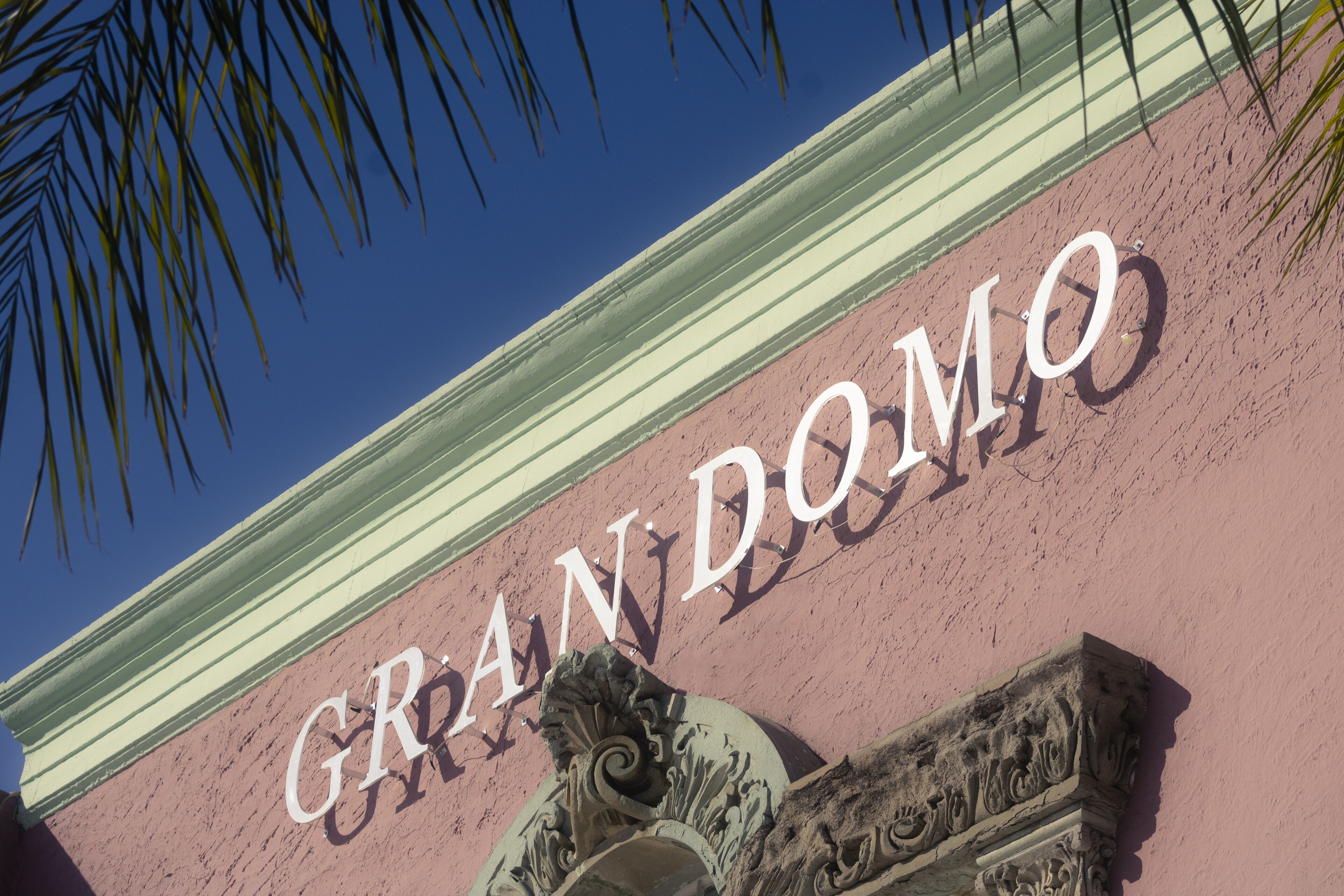 A building facade with the name "GRAND DOMO" in large letters.