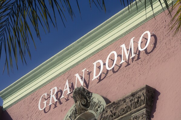 A building facade with the name "GRAND DOMO" in large letters.