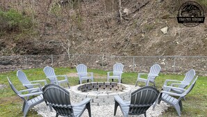 Un foc a la terra de forma circular envoltat de vuit cadires Adirondack.