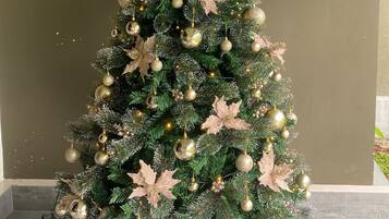 Uma árvore de Natal com enfeites dourados e prateados, um bico de estrela e folhas de flores de estrela.