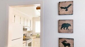 A kitchen with white cabinets, a microwave, and a window.