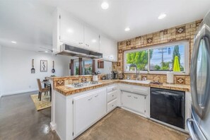 Enjoy meals in this kitchen with dishwasher and dining area nearby.