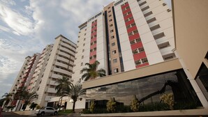 A high-rise hotel building with multiple floors, large windows, and a modern architectural design. - Villas diRoma com um dia no Acqua Park (Caldas Novas)