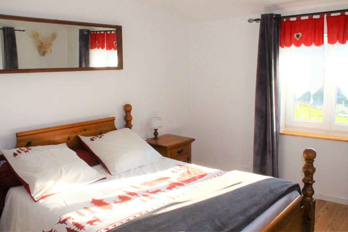 A bed with a wooden headboard, two white pillows, and a patterned bedspread.