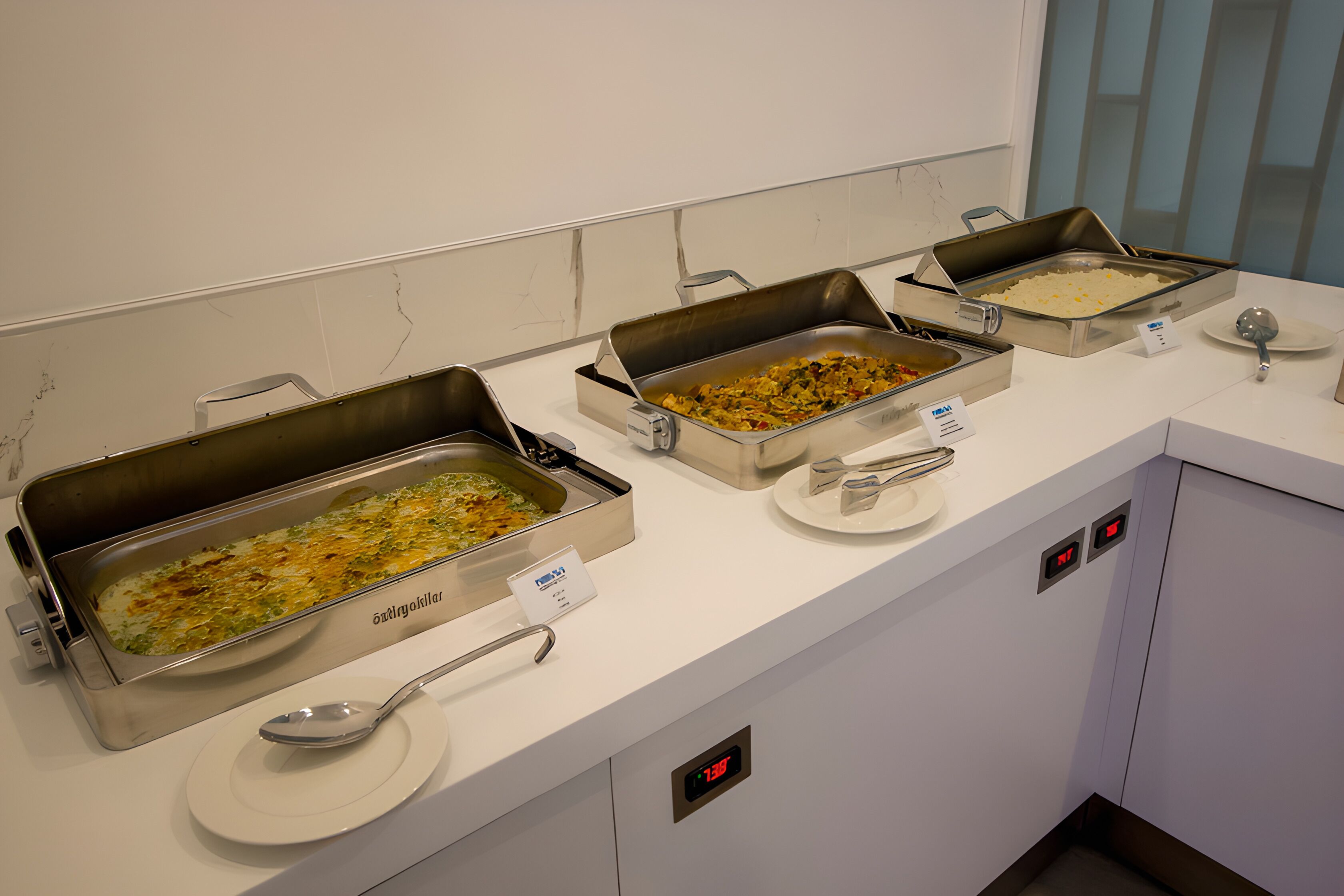 A buffet setup with various dishes in metal serving trays.