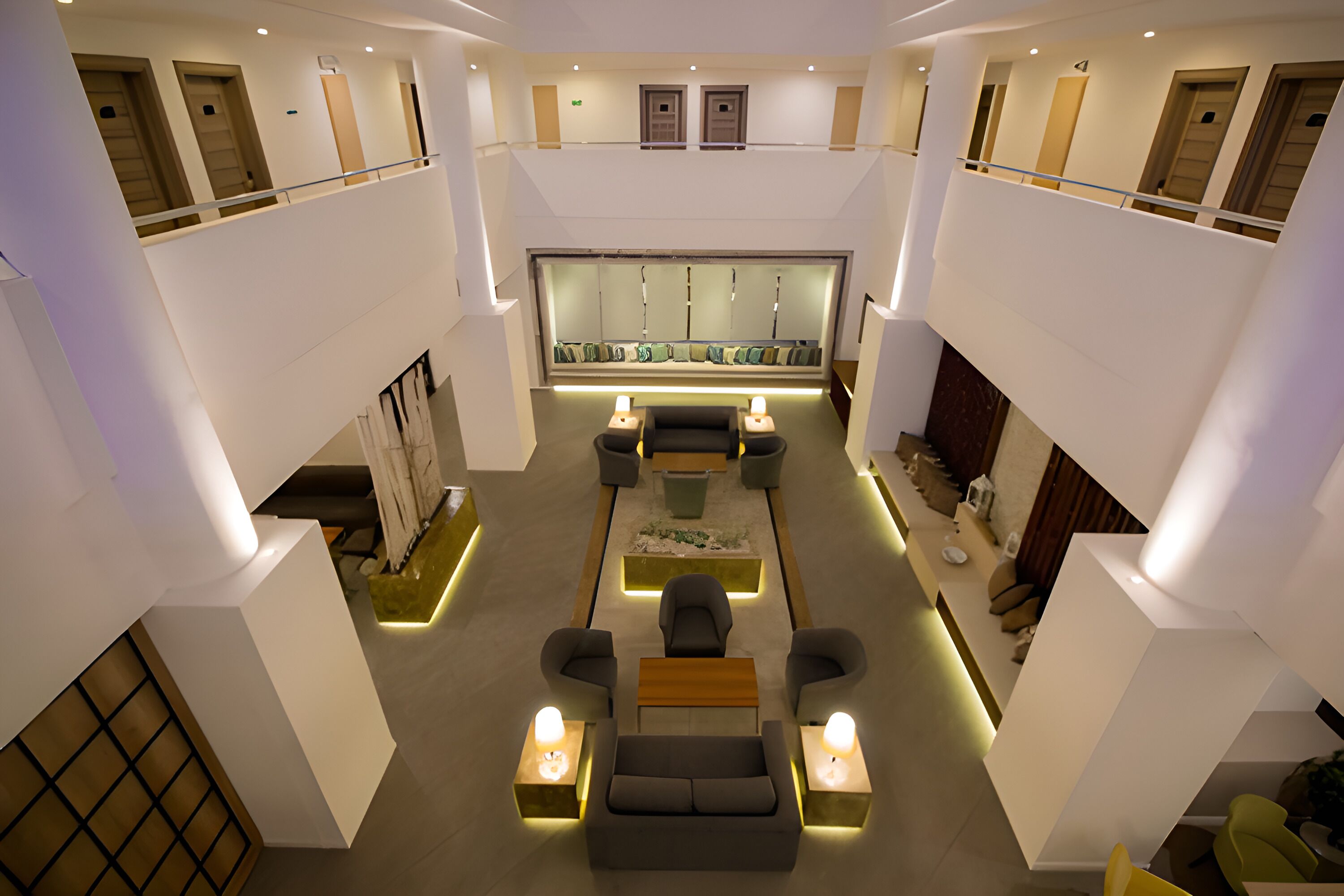 A spacious lobby with a central seating area, a reception desk, and a high ceiling with natural light.