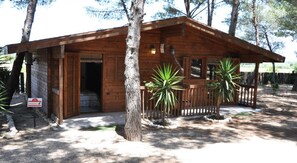 A wooden cabin with a porch, a door, and a sign indicating a pharmacy. - Tenuta del Barco (Taranto)