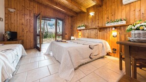 A wooden cabin with two beds, a television, and a table with flowers. - Tenuta del Barco (Taranto)