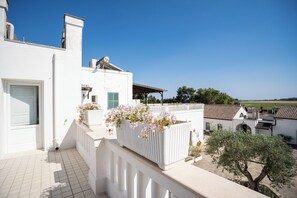 A white building with a tiled balcony and a flower planter. - Tenuta del Barco (Taranto)