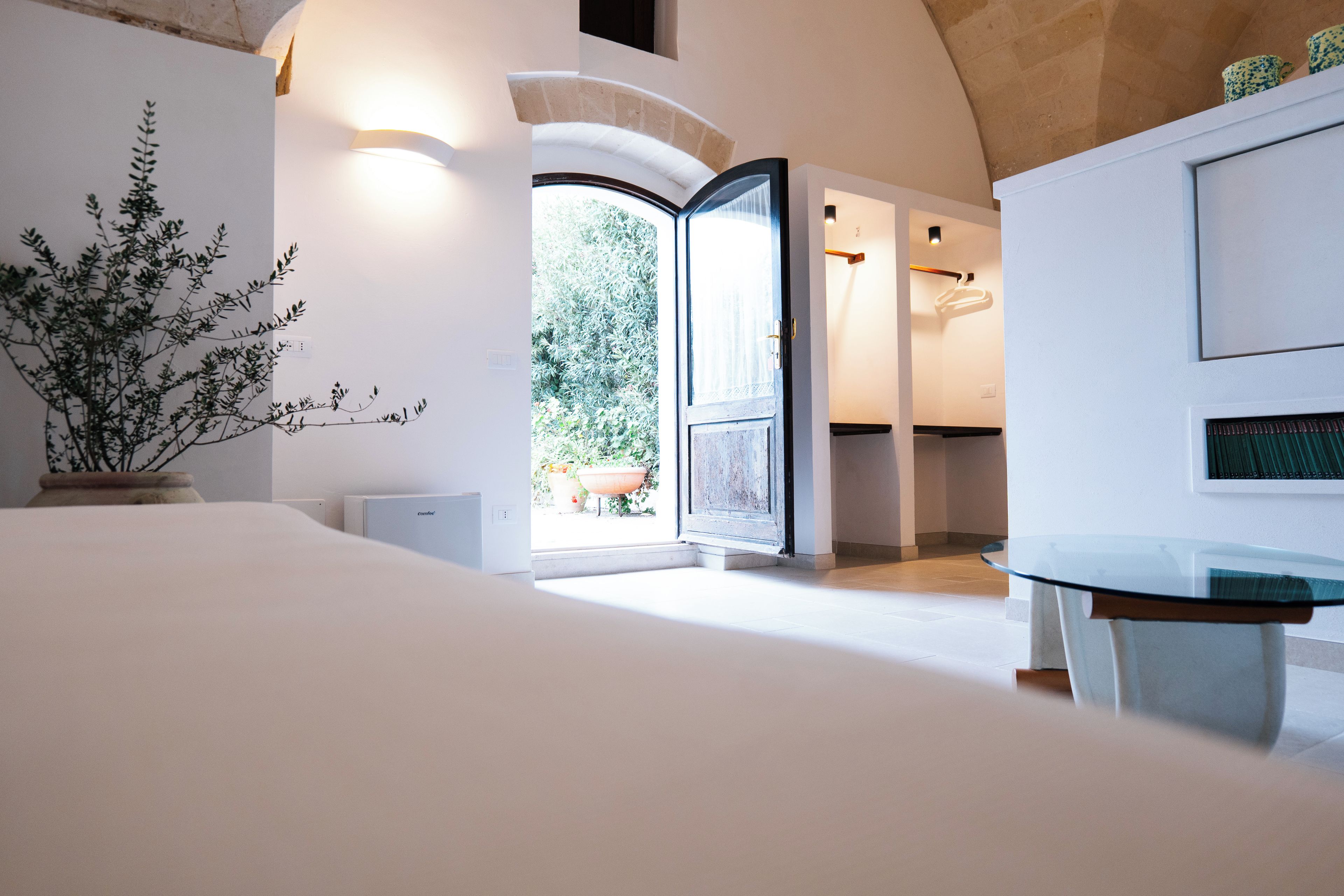 Un interior moderno con una cama grande, una mesa de vidrio y vistas al exterior.