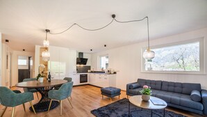 A modern living space with a dining area, sofa, and kitchen. - Apartment 'Sankt Martin' with Mountain View, Private Terrace and Wi-Fi (Sankt Martin)