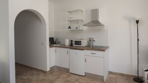 A modern kitchen with white cabinetry, a microwave, a coffee maker, and a built-in oven. - Apartment Siempreviva on Finca Falcon Cresta (Agüimes)