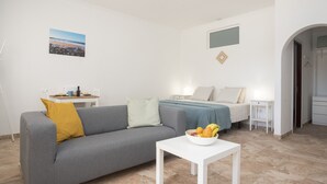 A modern, minimalist bedroom with a bed, bedside tables, and a sofa. - Apartment Siempreviva on Finca Falcon Cresta (Agüimes)