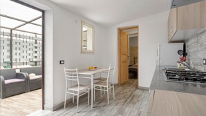 Une cuisine moderne avec un coin repas, une vue dégagée grâce à une grande fenêtre et un espace de vie séparé avec un canapé.