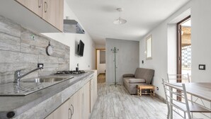 Une cuisine moderne dotée d’un plan de travail en granit, d’un évier en acier inoxydable et de meubles en bois.
